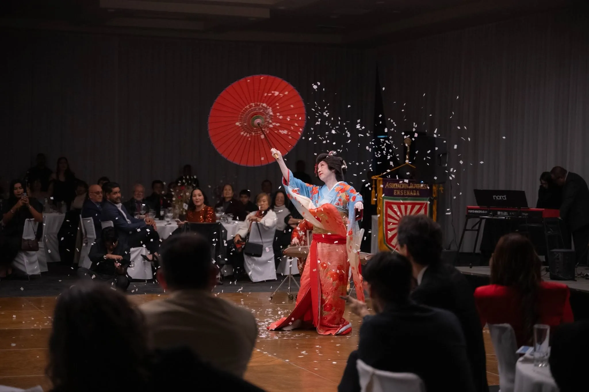 Bailarina con kimono y sombrilla roja durante una presentación de danza japonesa del Centro